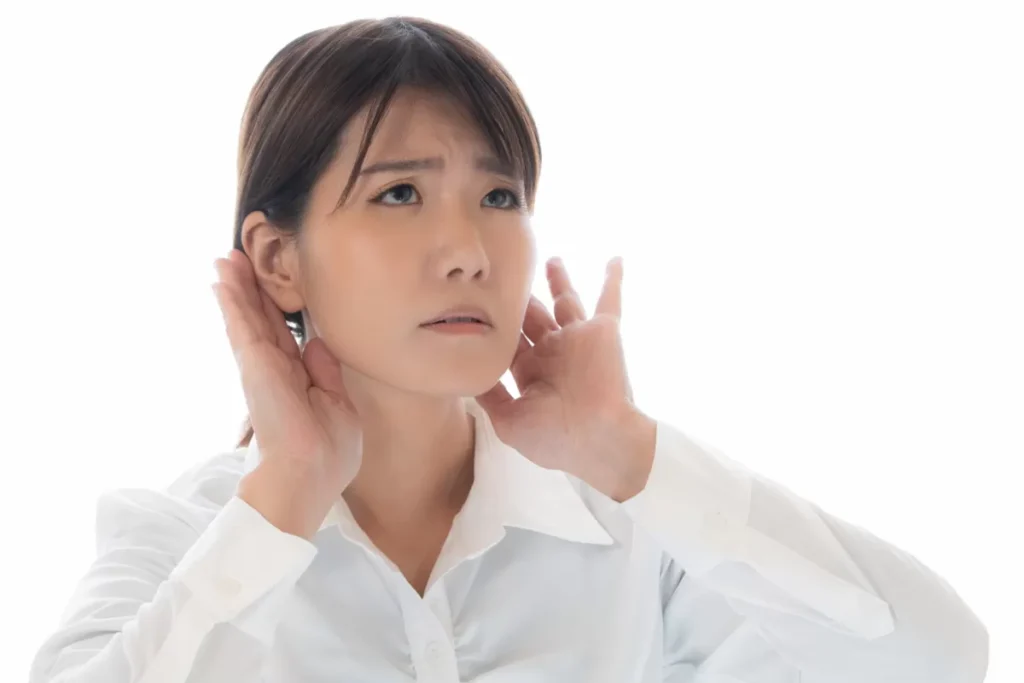 耳を澄ませて音を確かめる女性